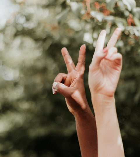 Two people holding up peace signs